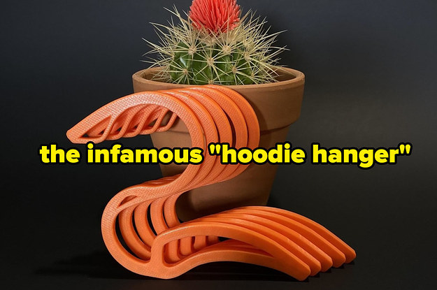 Five orange hoodie holders up against a potted cactus
