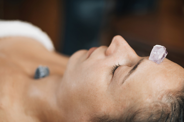 Closeup photo of a person with a crystal on their forehead and one on their throat