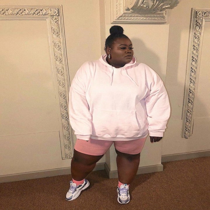 reviewer wearing the bike shorts in pink with a white sweatshirt