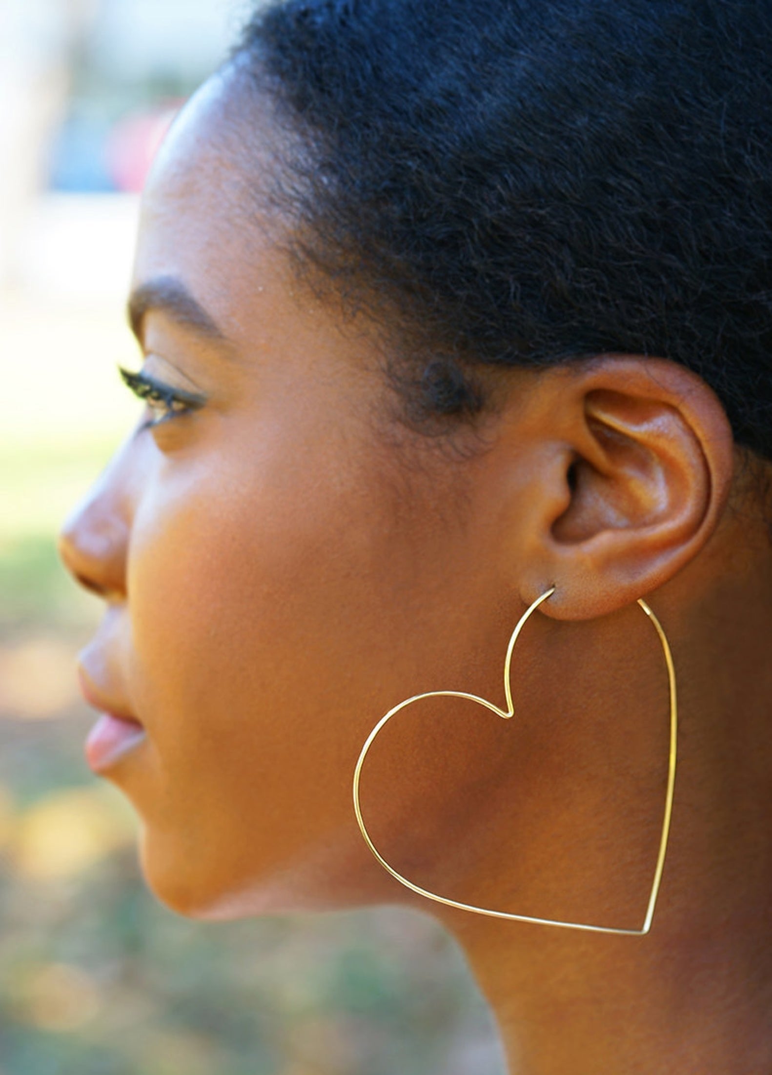 model wearing heart-shaped hoop earrings