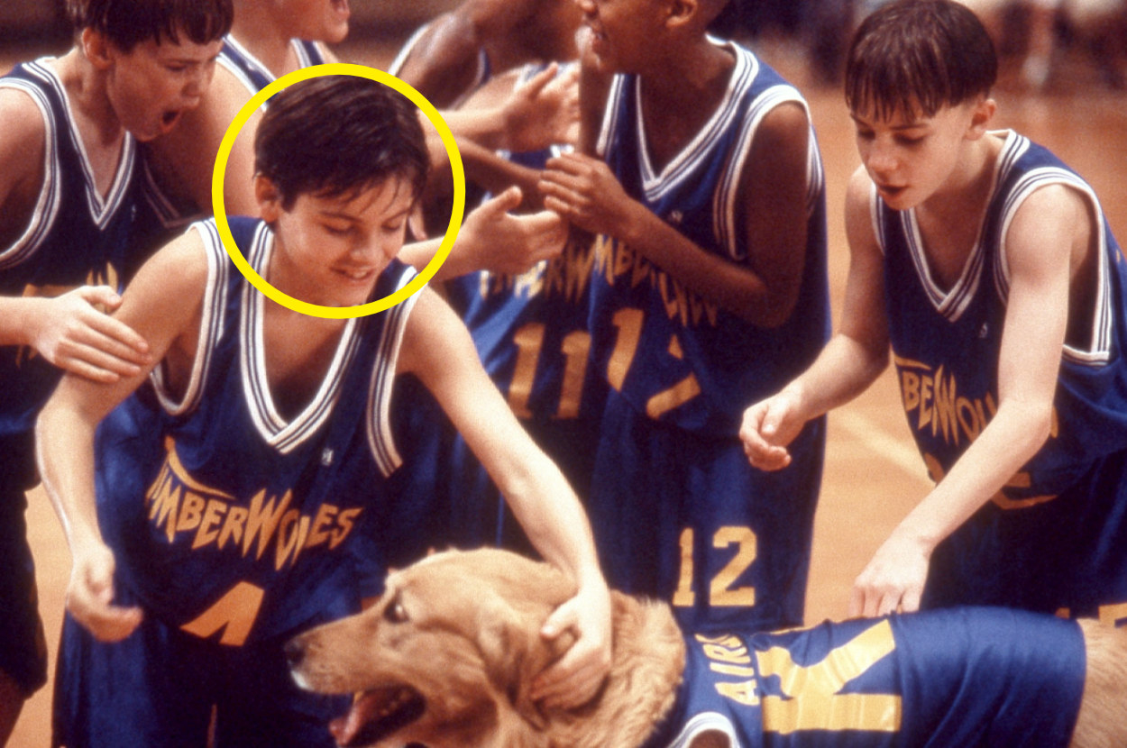 Josh petting Buddy surrounded by basketball team
