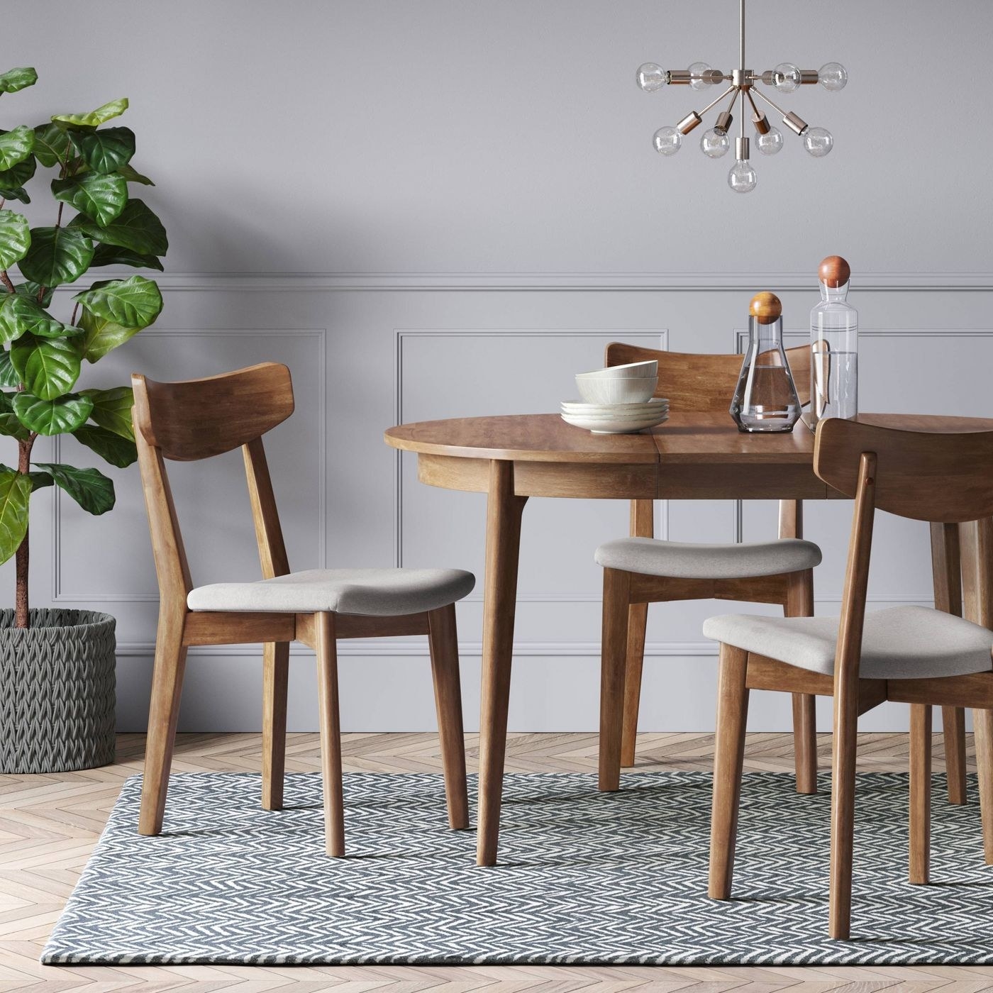 wood rounded dining table with chairs around it