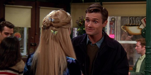 Larry and Phoebe stand facing each other in Central Perk