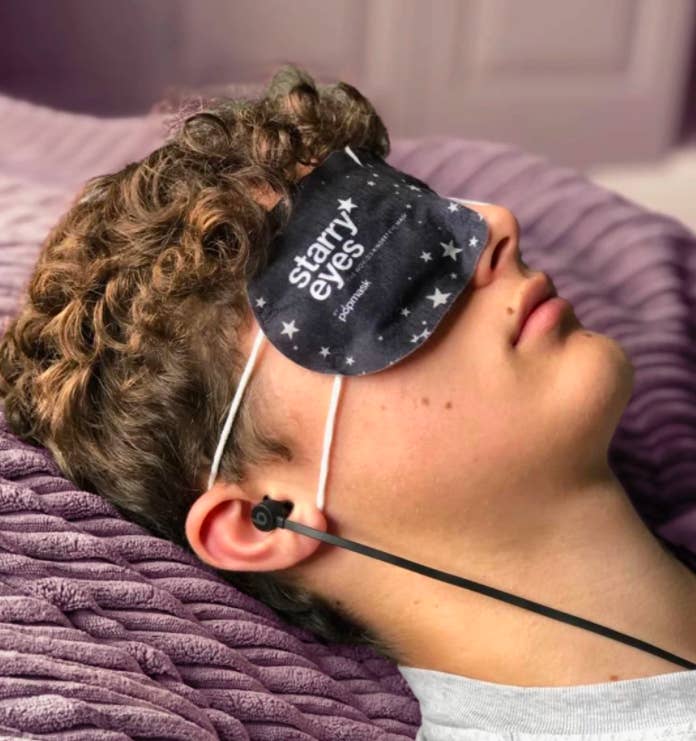A person wearing the mask while sleeping with headphones in