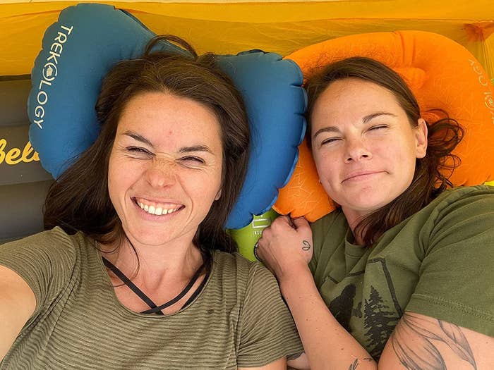 Two people with their heads on camping pillows