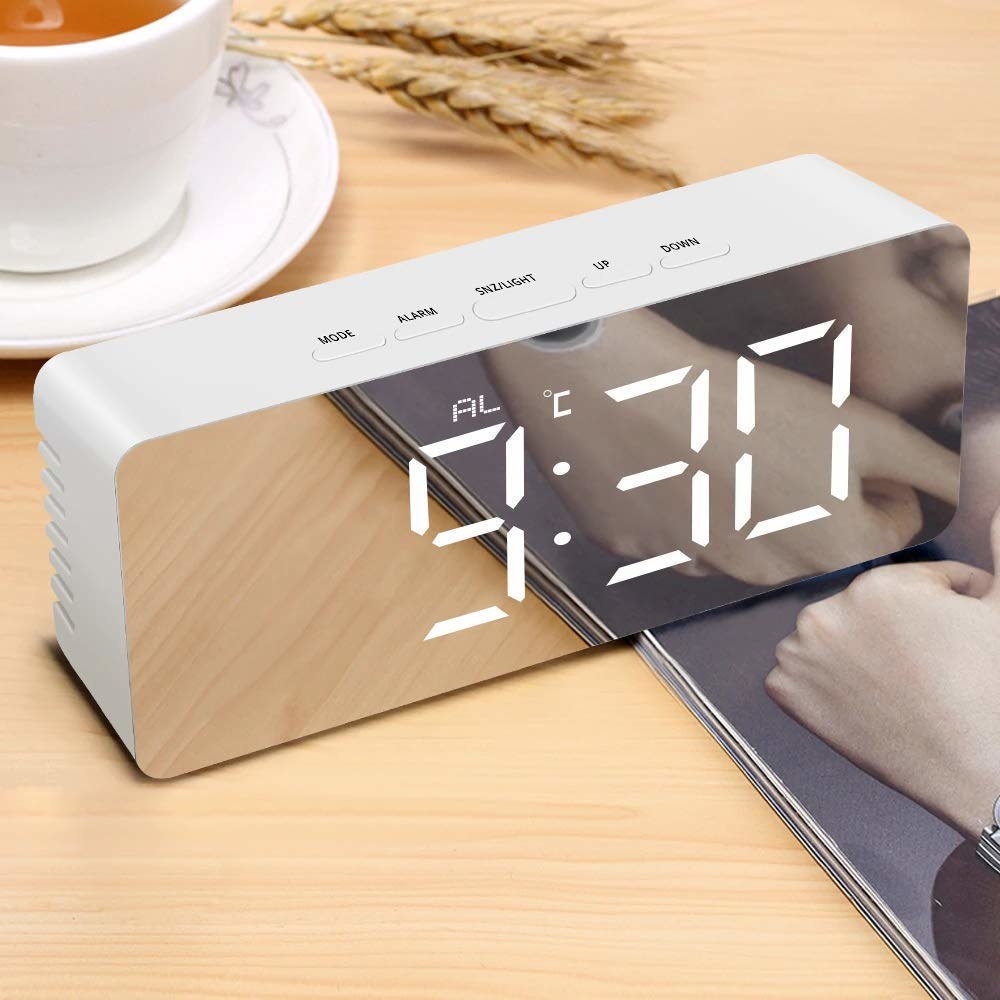 A rectangular digital alarm clock with a mirror finish