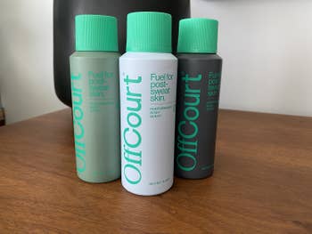 Green, white, and black spray bottles with green tops