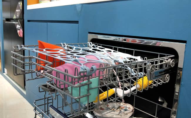 open top rack of dishwasher with net keeping stuff in place