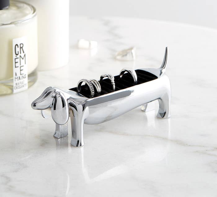 a dog-shaped ring holder with four rings on its back