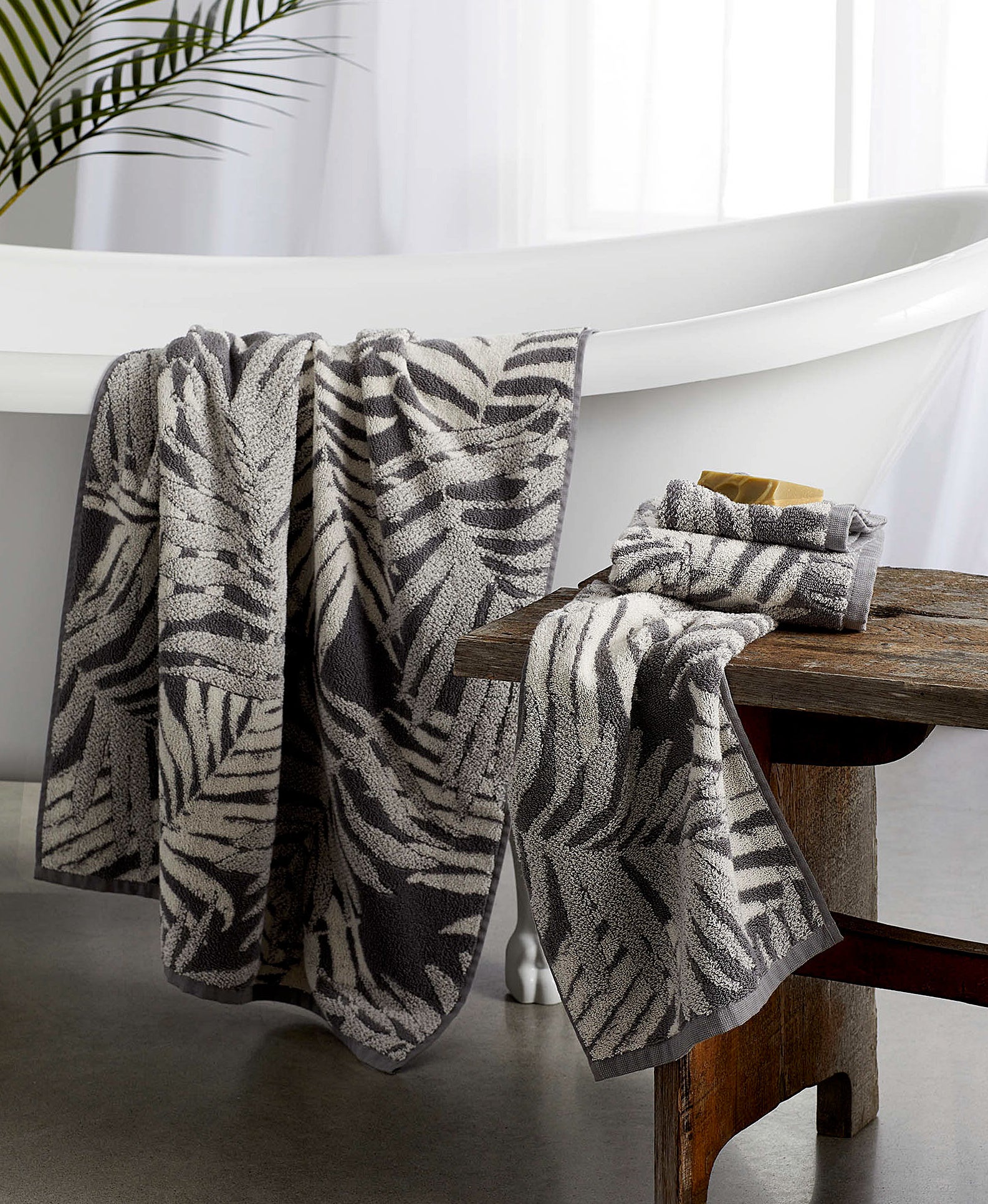 two towels with palm leaf patterns in a bathroom