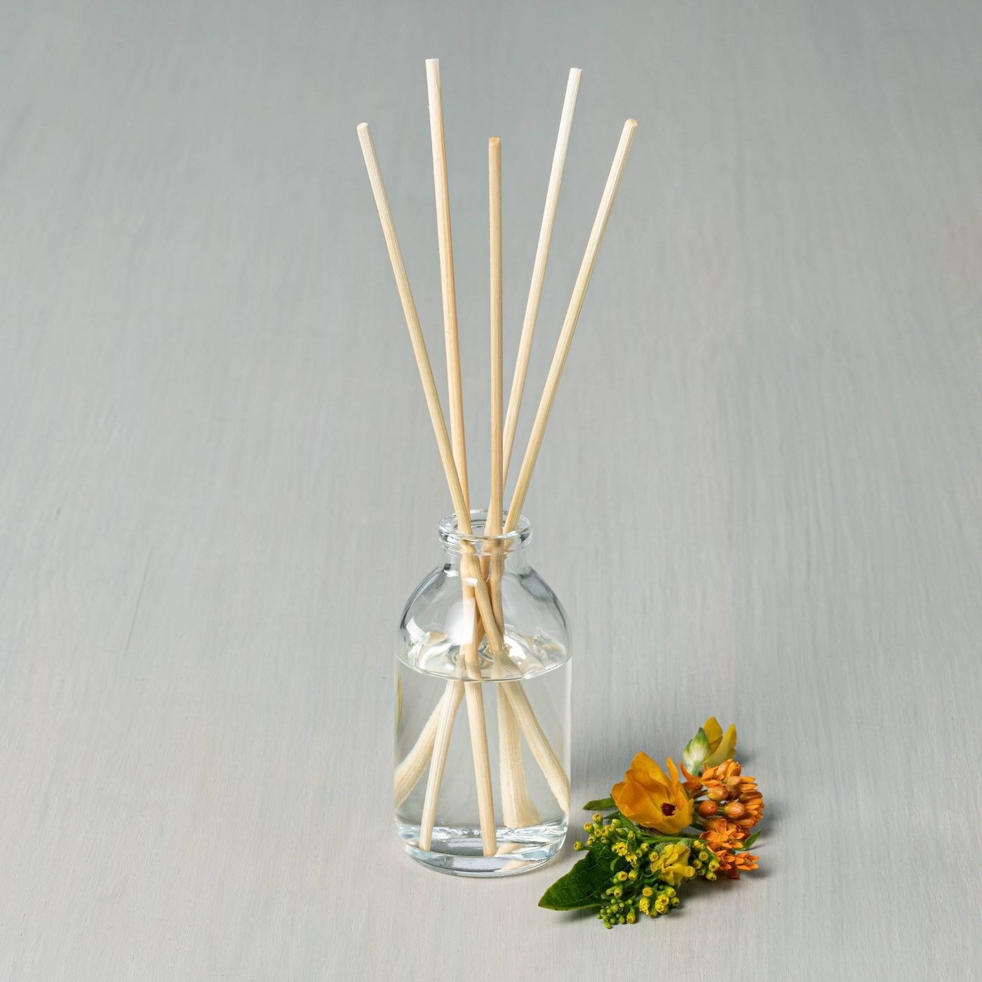 An oil diffuser next to flowers