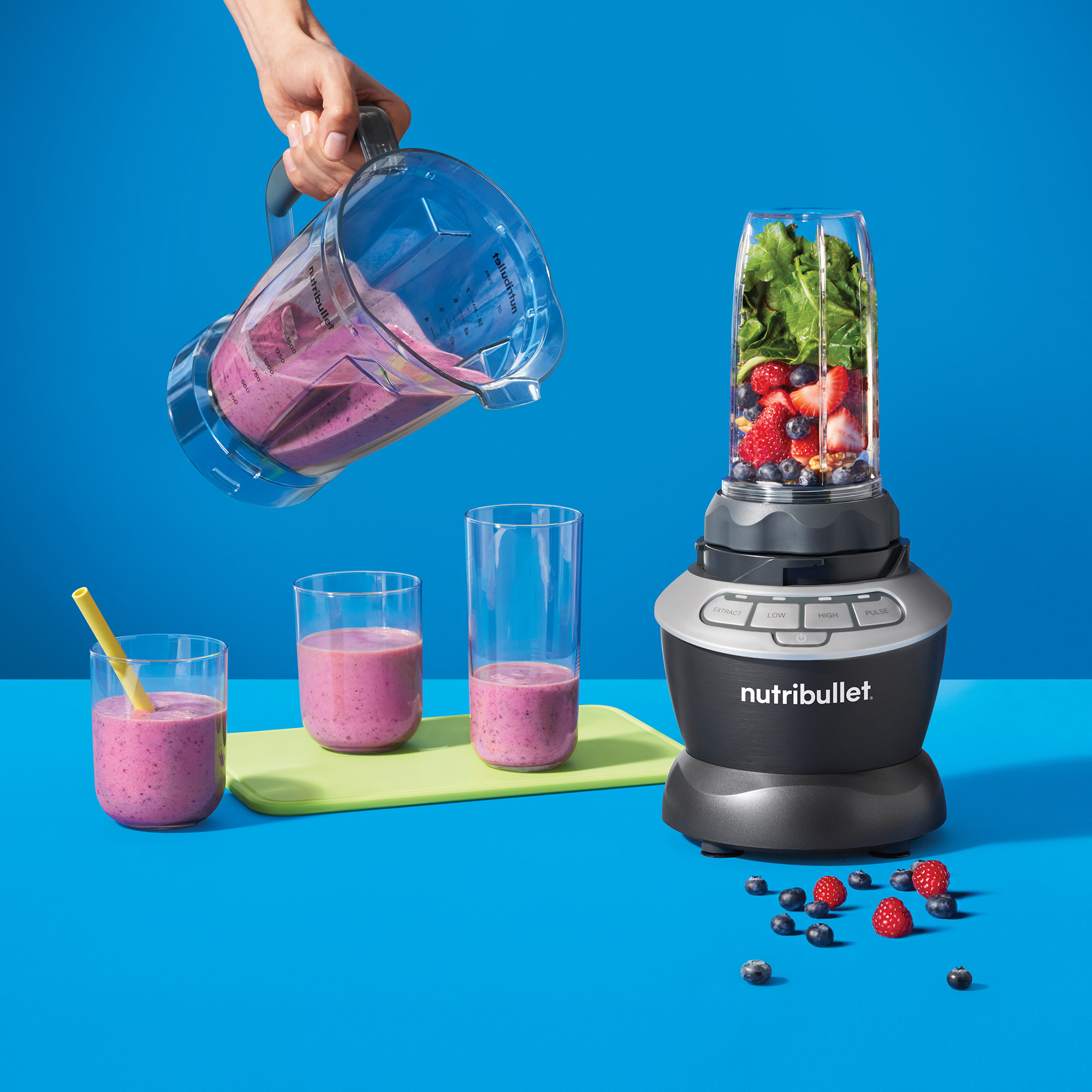 The blender with the single-serve cup on it, while a model holds the larger cup.