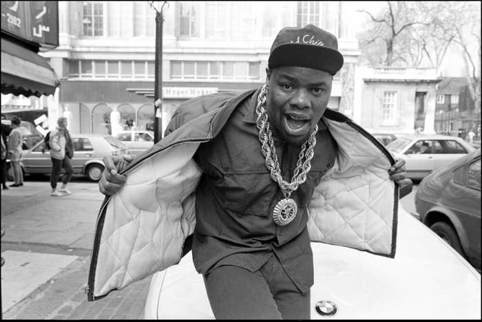 Biz Markie holding his jacket open to show his thick necklace