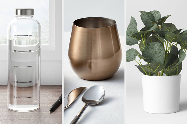 A water bottle on the left and a wine glass in the middle and a faux plant on the right