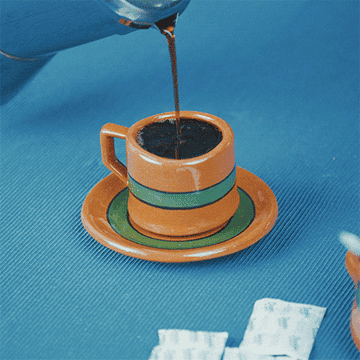 A GIF of someone pouring black coffee into a mug until it overflows