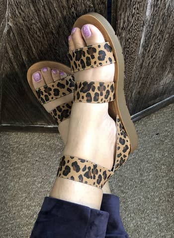 a reviewer wearing the sandals in leopard