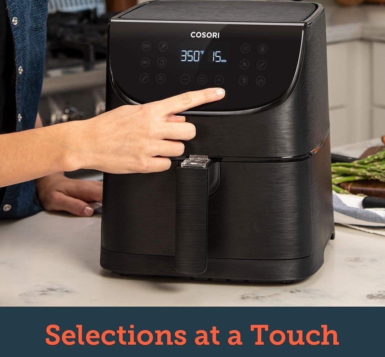 A person pressing a button on the face of the air fryer