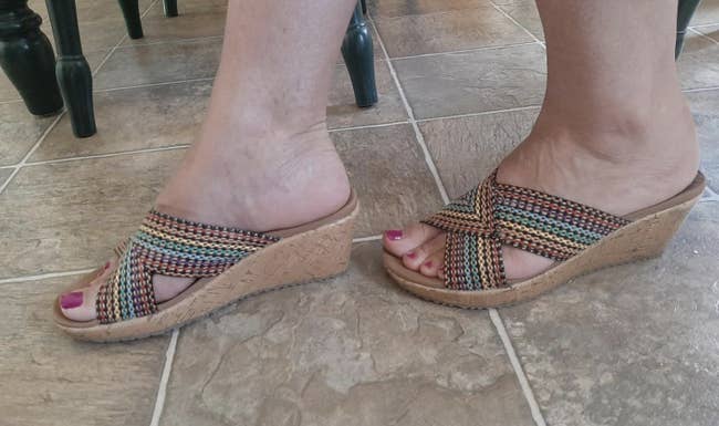 reviewer wearing the rainbow stitch wedge slip ons