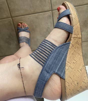 close-up of a reviewer's foot wearing the sandals in blue
