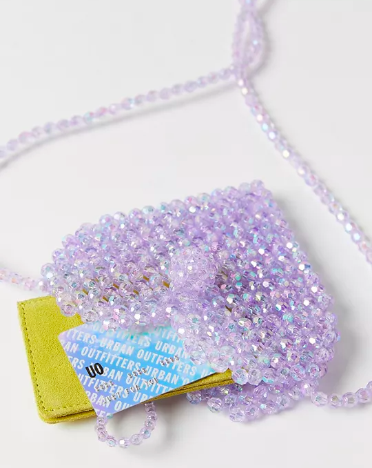 a beaded heart-shaped purse with a wallet and a card sticking out the top