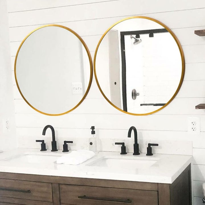 Two gold-accented mirrors above sinks