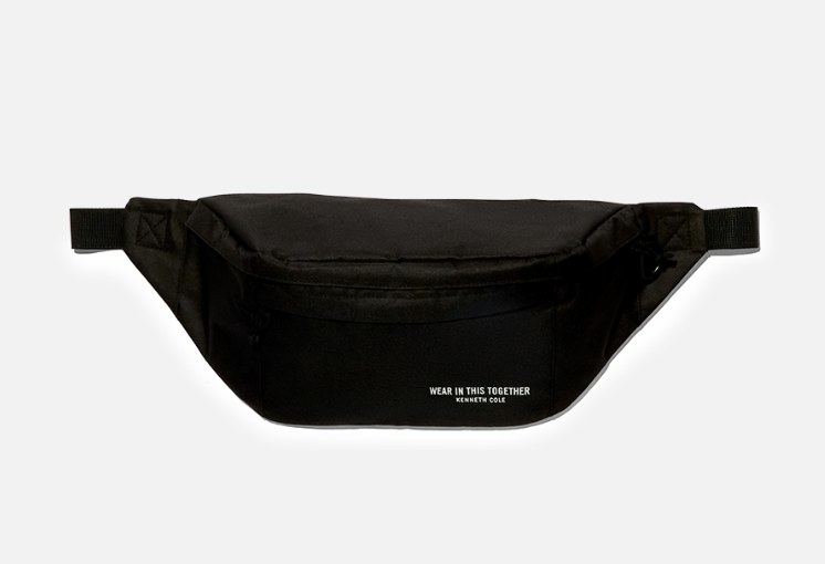 A black fanny back with an adjustable strap with &quot;WEAR IN THIS TOGETHER KENNETH COLE&quot; written in small white print on the bottom