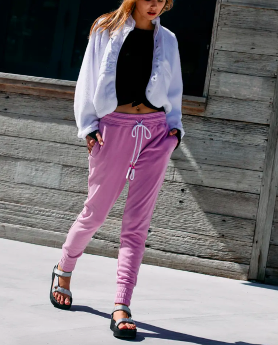 A model walking down the street in the pink sweat pants