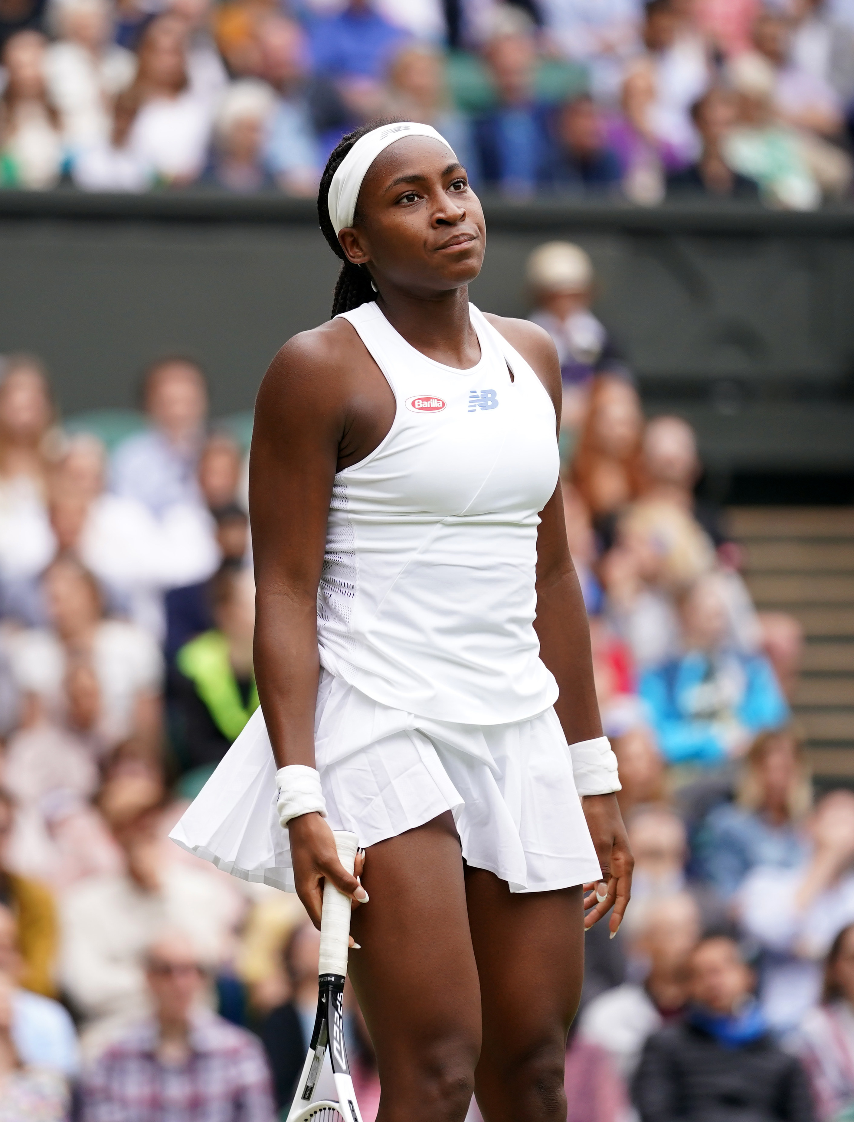 Photo of Coco Gauff looking annoyed in a white tennis outfit