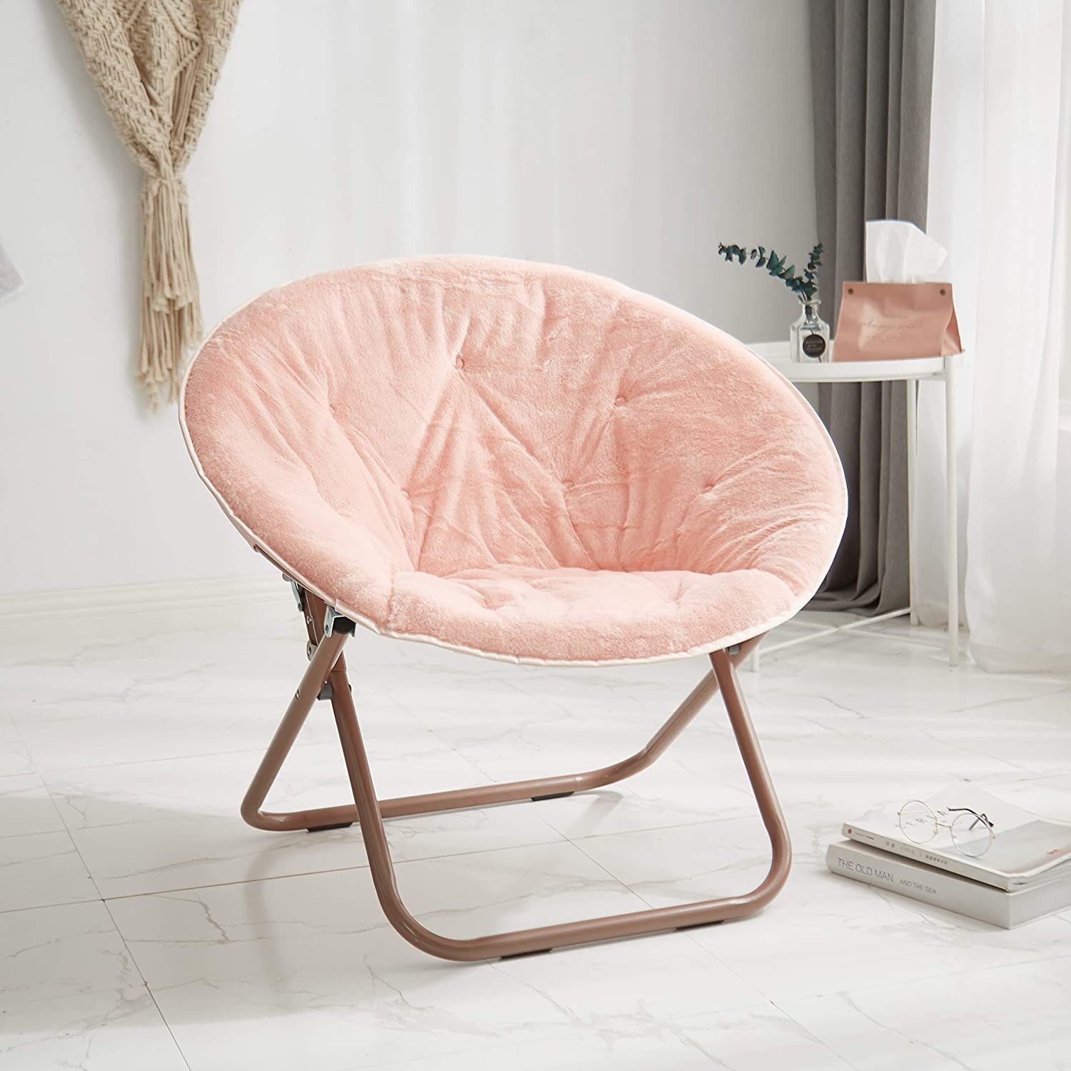 Pink folding saucer chair placed in room