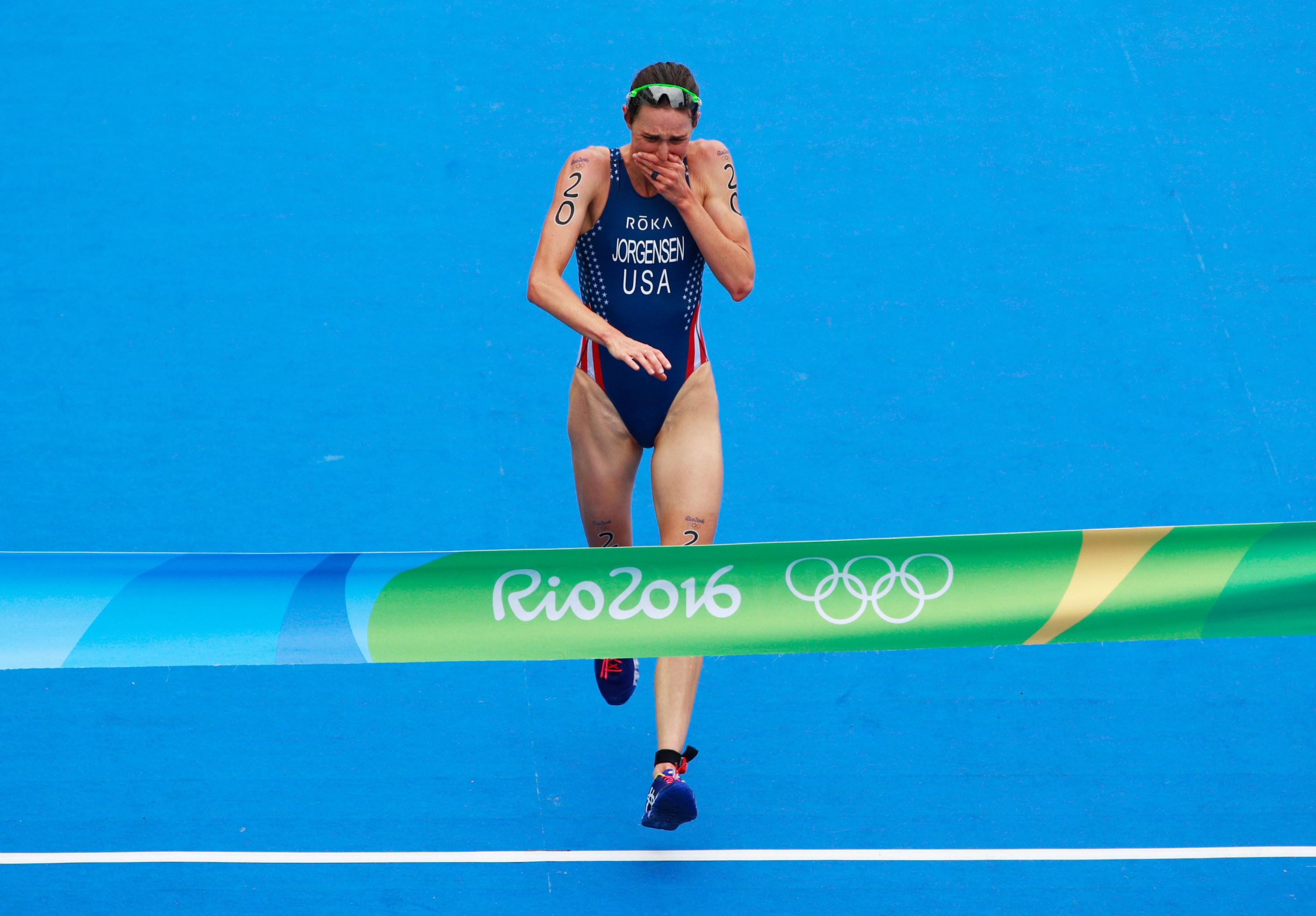 Swimmer crying as she runs across finish line