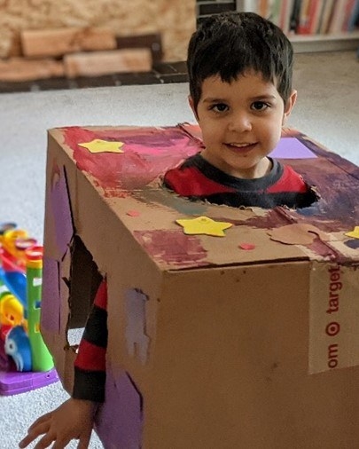 Child playing with a Cardboard box made into a robot