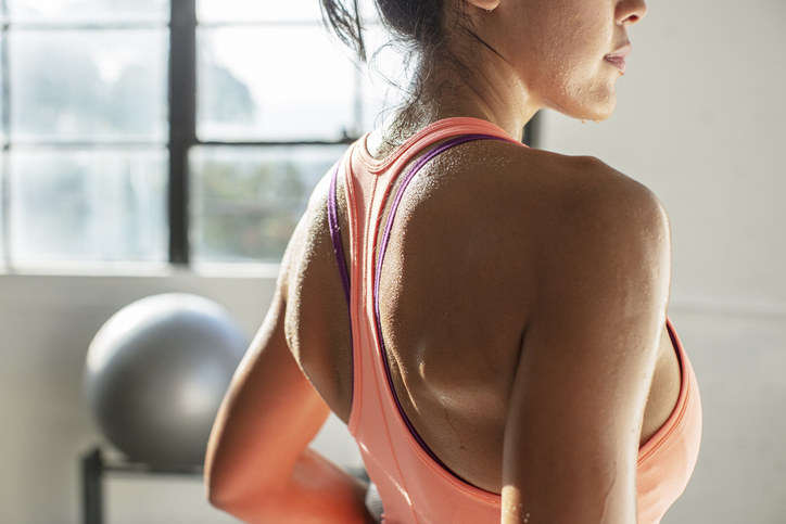 A sweaty woman working out in a sports bra