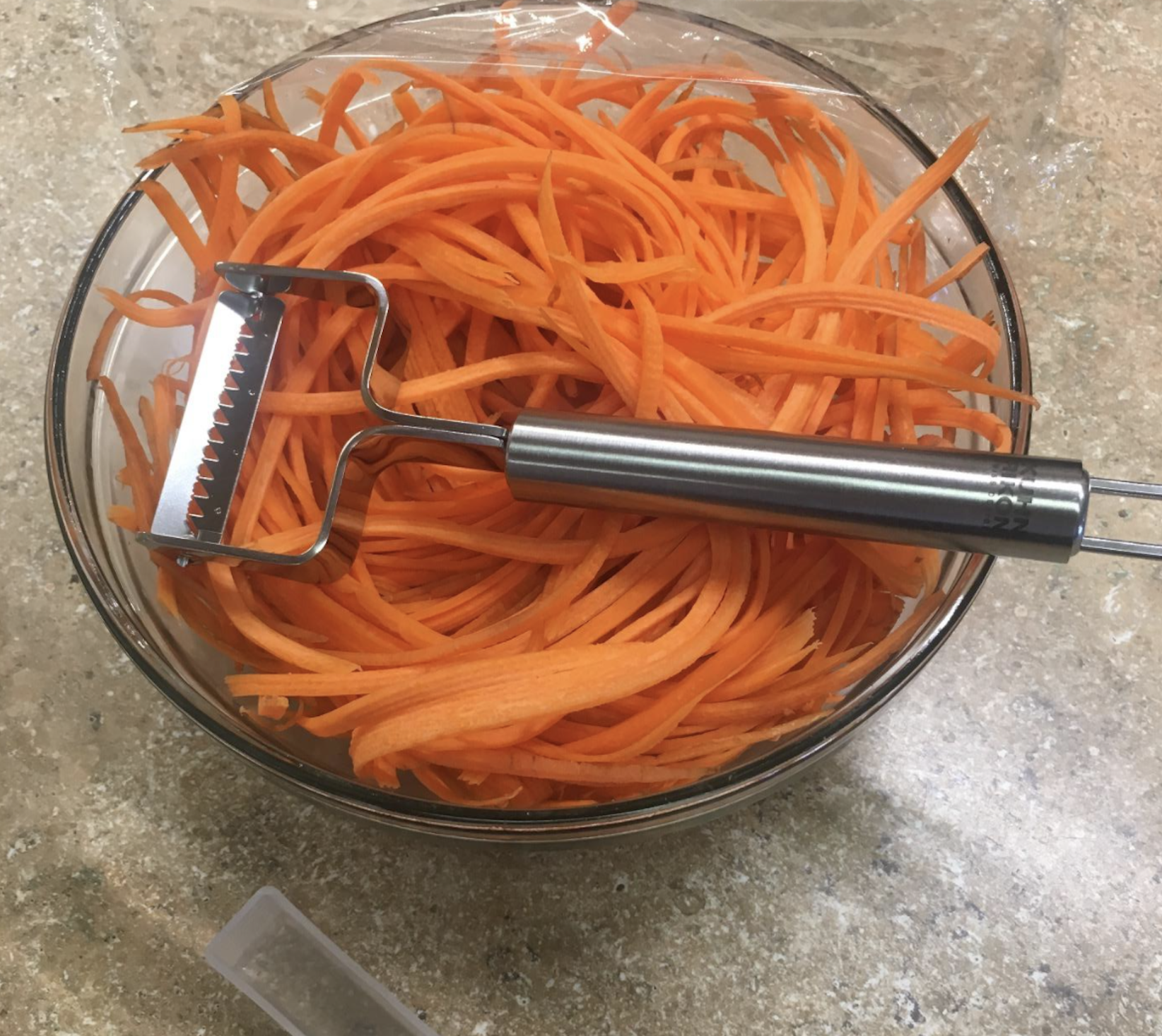 Reviewer photo of julienned carrots with a peeler on top of them