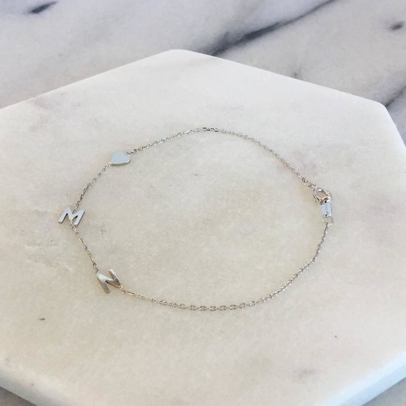 the gold bracelet with letter and heart charms