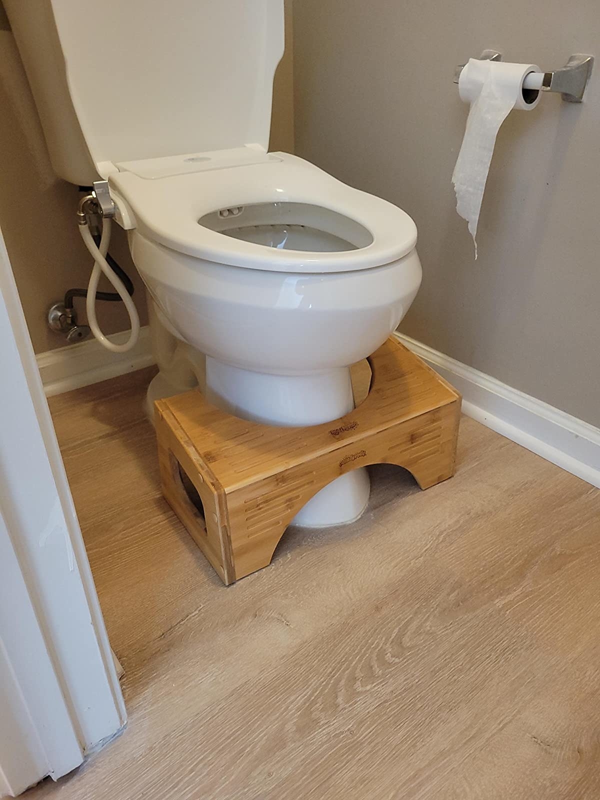 The bamboo squatty potty next to reviewer&#x27;s toilet
