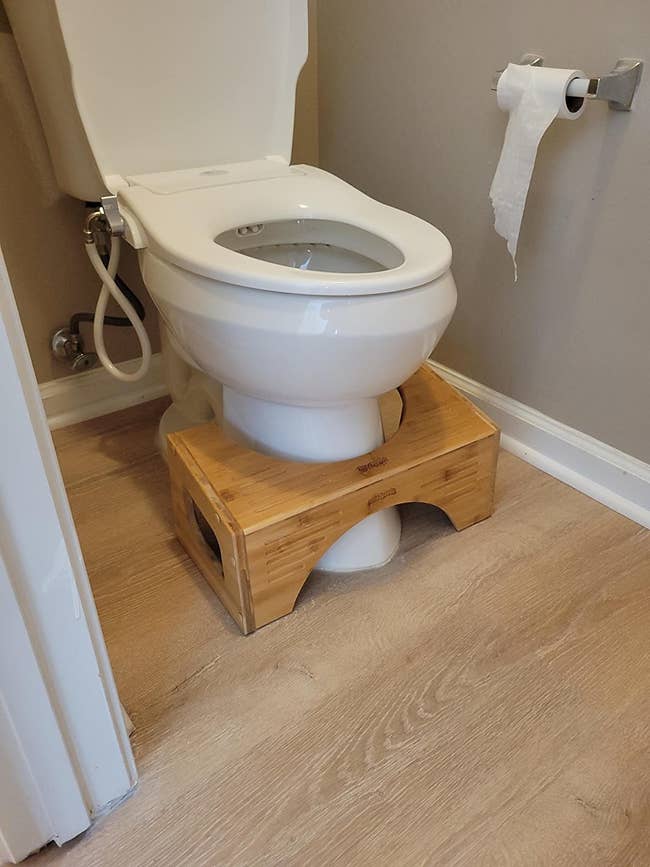 The bamboo squatty potty next to reviewer's toilet