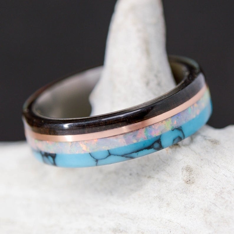 the ring made with Blackwood, Rose Gold, Opal, and Turquoise layered on top of each other