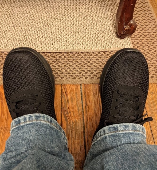 Reviewer wearing black sneakers with jeans