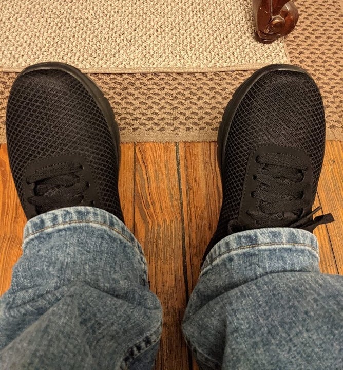 Reviewer wearing black sneakers with jeans