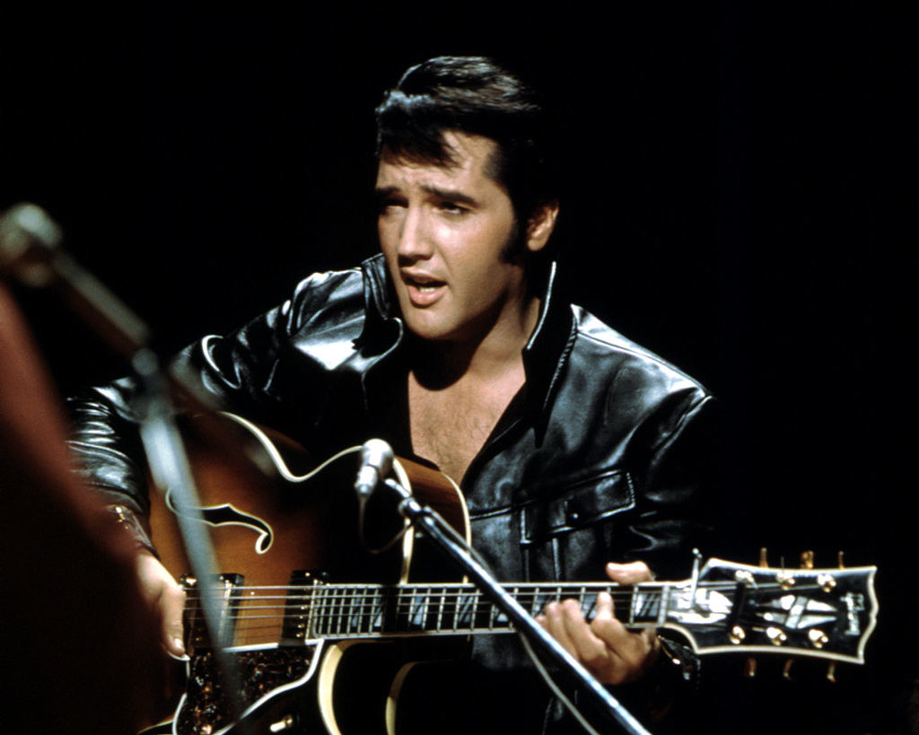 Elvis playing guitar on stage