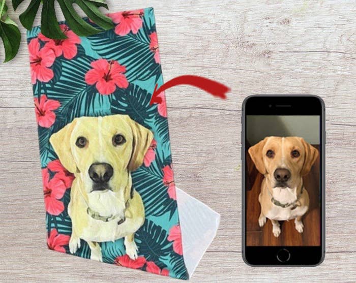 The cooling towel with a dog printing on it next to a phone with a photo of the same dog