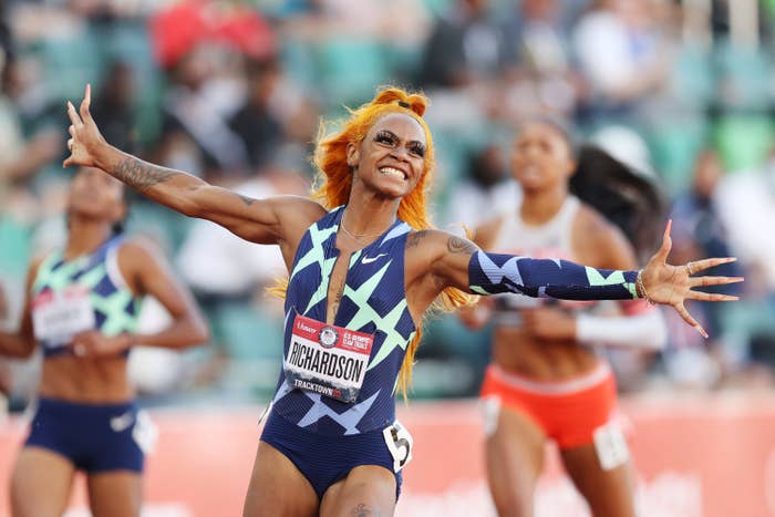 Sha&#x27;Carri, with arms raised and smiling, celebrates her performance in a race