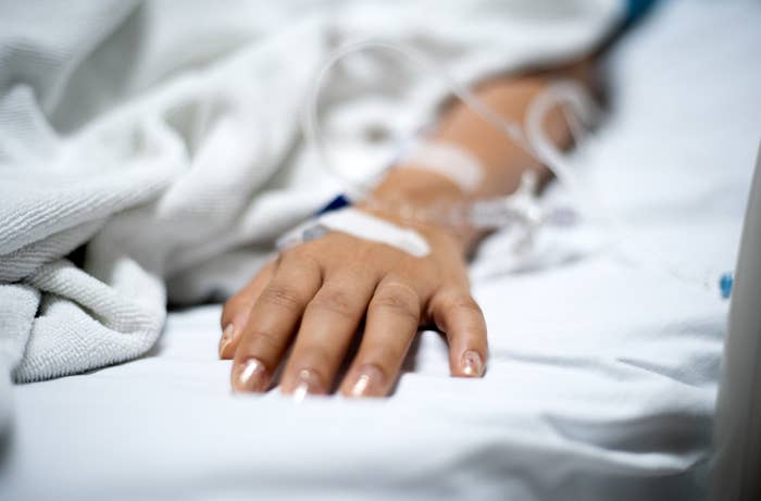 We see a person&#x27;s hand on a hospital bed