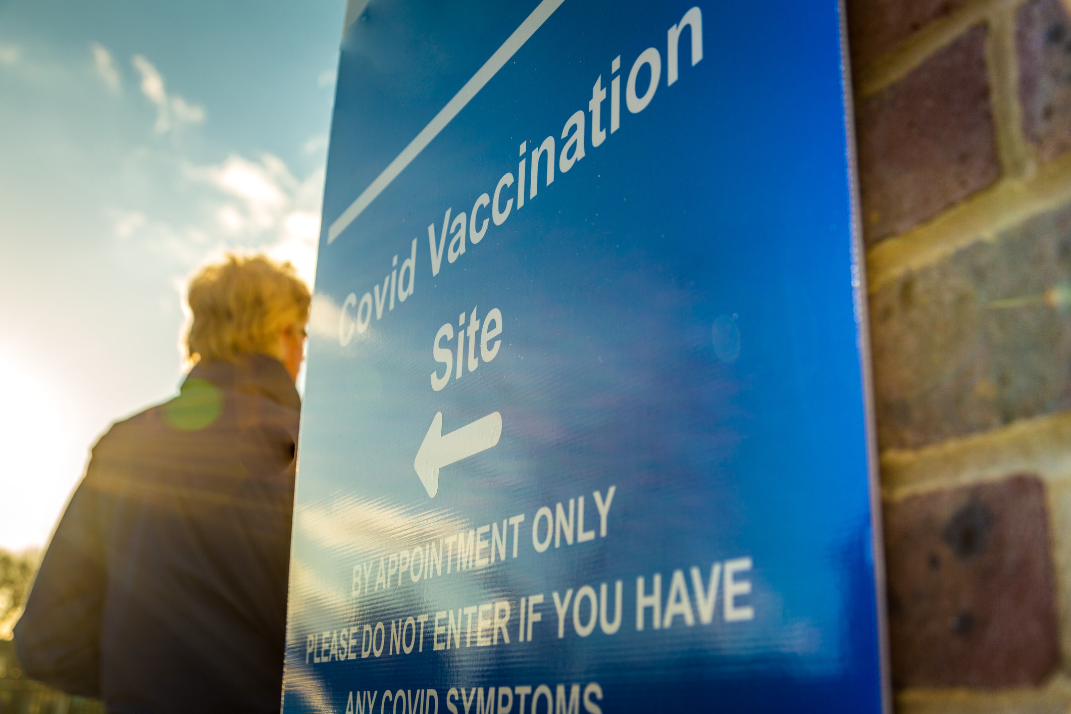 We see a sign pointing to a COVID-19 vaccination site