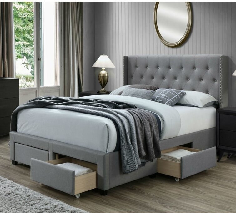 gray bed with tufted headboard and four rolling storage drawers underneath