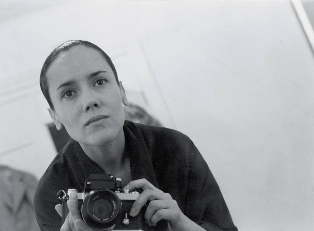 Self-portrait of woman holding camera in mirror