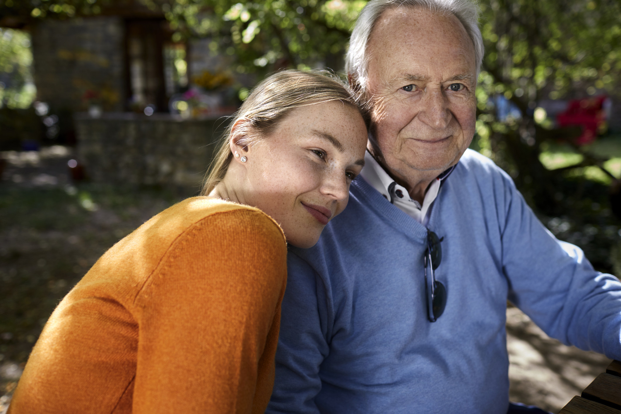 A young woman leans on her grandfather&#x27;s shoulder