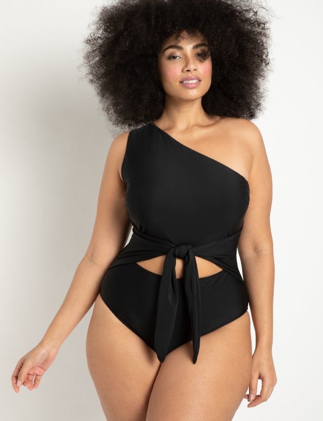 model wearing the tie-front one-piece in black