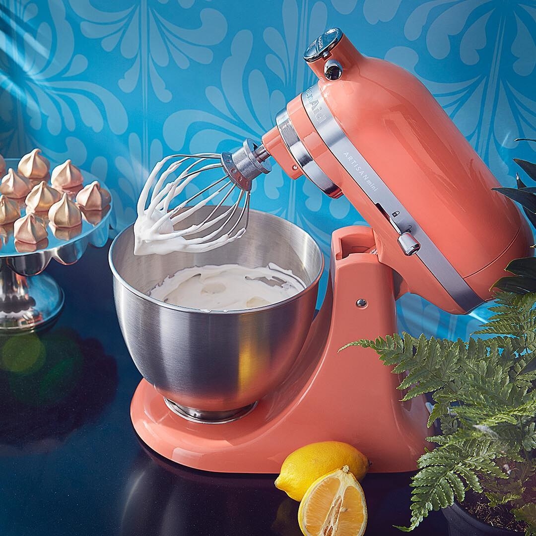 a photo of the kitchenaid mixer in peach with whipped frosting inside