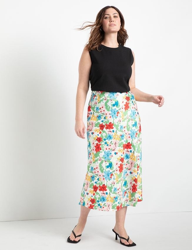 model wearing the floral satin skirt with a black tank and heels